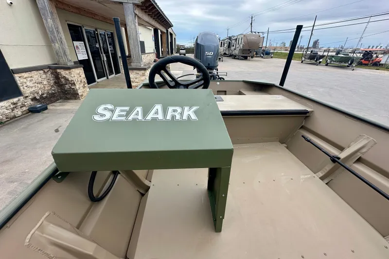 Slide: The Image of 2026 SeaArk 1652 Special boat interior with steering wheel and console, parked outdoors. - 14