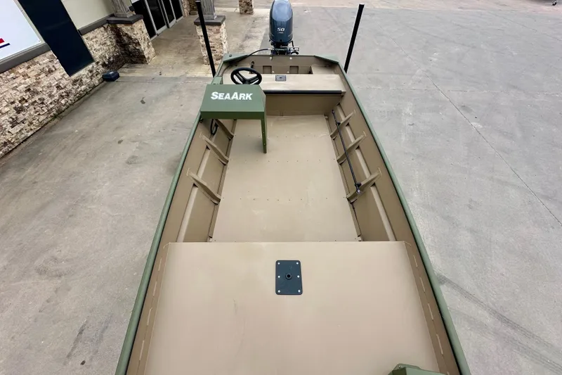 Slide: The Image of 2026 SeaArk 1652 Special boat, empty interior view, parked on concrete surface. - 16