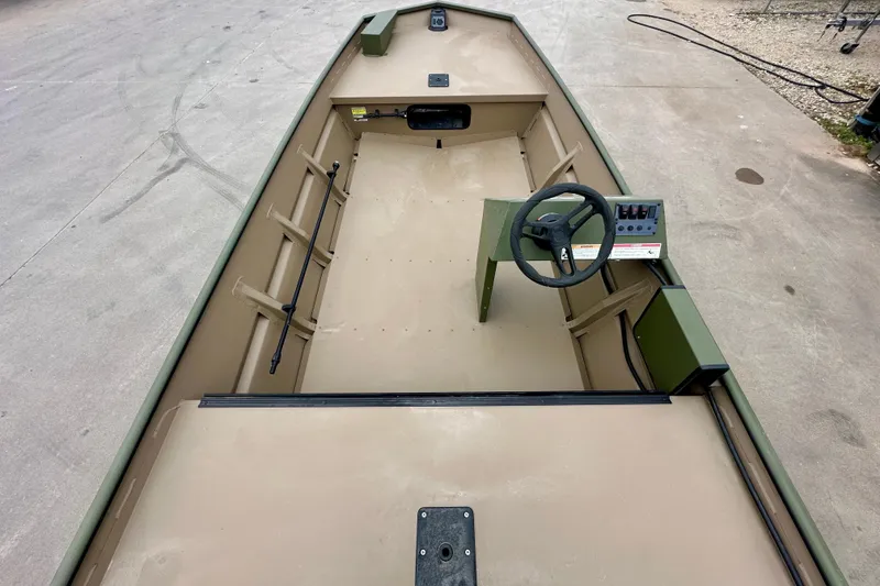 Slide: The Image of 2026 SeaArk 1652 Special boat interior with steering console, beige and green design. - 9