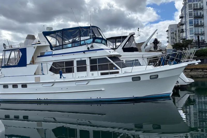 Slide: The Image of 1986 Ponderosa 42' yacht docked in marina, reflecting on calm water. - 1