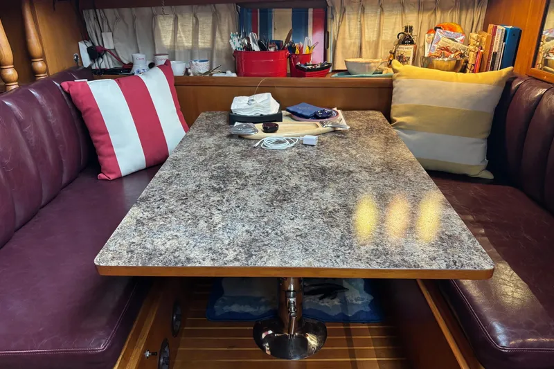 Slide: The Image of Cozy dining area in a 1986 Ponderosa 42' yacht with cushioned seating and decorative pillows. - 13