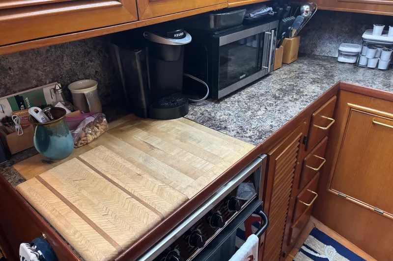 Slide: The Image of Kitchen area in a 1986 Ponderosa 42' boat with wooden cabinets and appliances. - 14