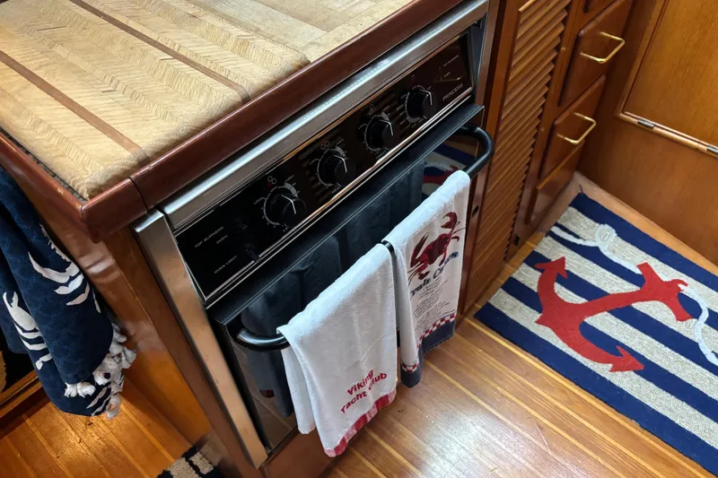 Slide: The Image of 1986 Ponderosa 42' yacht kitchen with oven, nautical decor, and wooden cabinetry. - 15