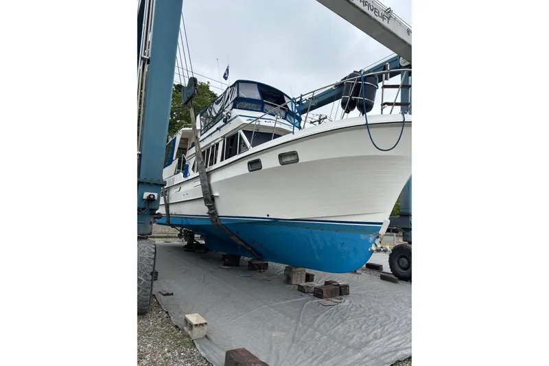 Slide: The Image of 1986 Ponderosa 42' boat on lift, white hull with blue bottom paint. - 2