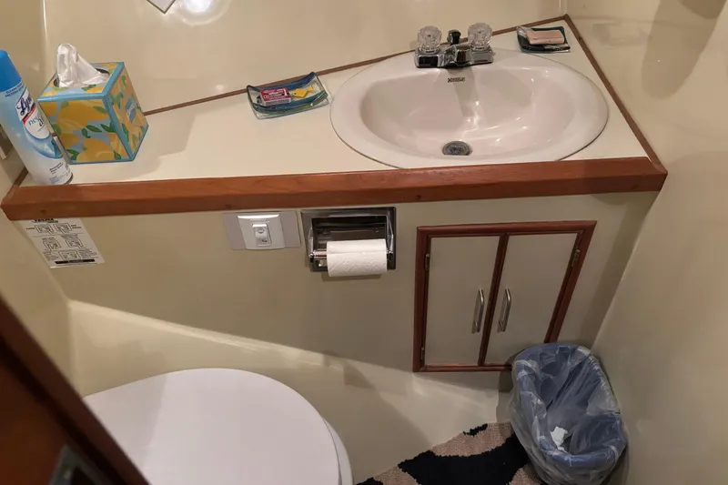 Slide: The Image of Compact bathroom in a 1986 Ponderosa 42' boat with sink, toilet, and storage. - 23
