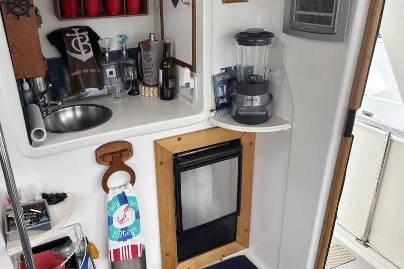 Slide: The Image of Compact kitchen area on a 1986 Ponderosa 42' boat with sink, blender, and mini fridge. - 32