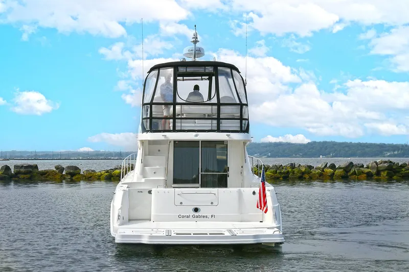 Slide: The Image of 2008 Sea Ray 44 Sedan Bridge on calm water near rocks. - 5