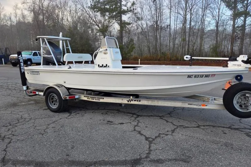 The Image of 2014 Hewes Redfisher 18 boat on trailer, parked outdoors with trees in background. - 0