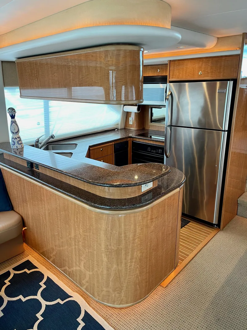 Slide: The Image of 2002 Bayliner 5788 yacht kitchen with modern appliances and wood finish. - 16