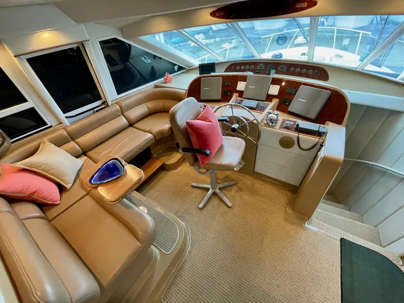 Slide: The Image of Luxurious 2002 Bayliner 5788 yacht interior with electronic Cummins QSMs, featuring a spacious helm and seating area. - 26