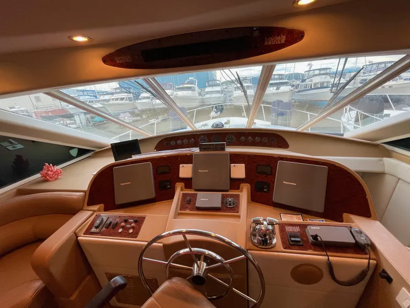 Slide: The Image of Bayliner 5788 2002 helm with electronic Cummins QSMs, marina view through windshield. - 28