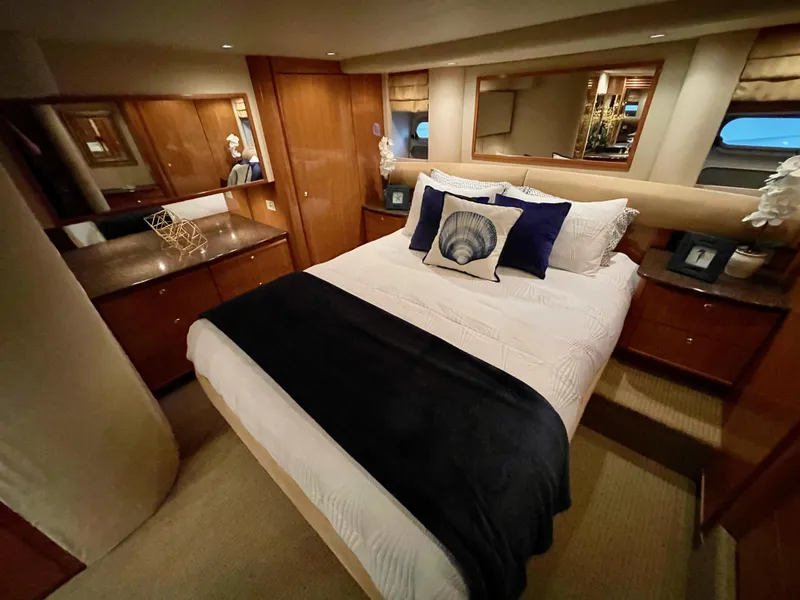 Slide: The Image of Luxurious bedroom interior of 2002 Bayliner 5788 yacht with elegant bedding and wooden cabinetry. - 41