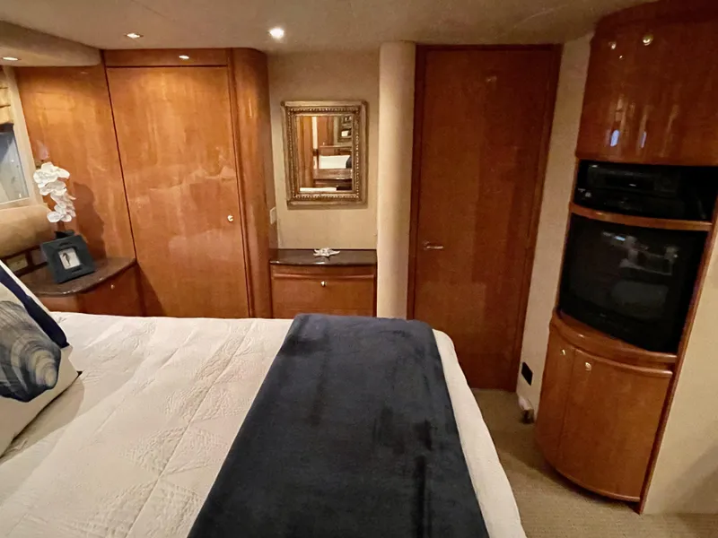 Slide: The Image of Luxurious bedroom interior of 2002 Bayliner 5788 yacht with wooden cabinetry and TV. - 48