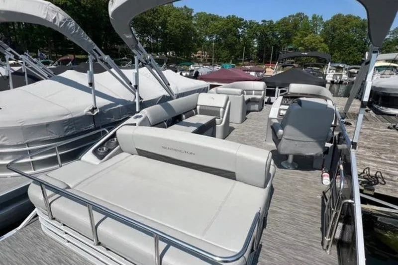 Slide: The Image of 2021 Bennington 23 LSB pontoon boat with spacious seating at a marina. - 10