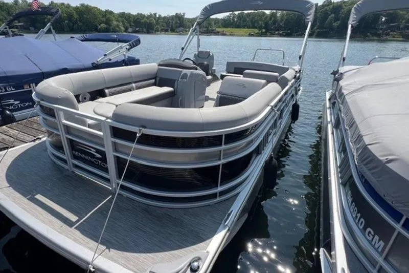 Slide: The Image of 2021 Bennington 23 LSB pontoon boat docked on a sunny lake. - 9