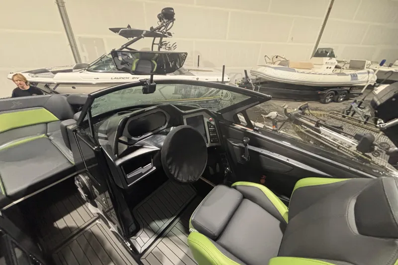 Slide: The Image of 2022 MasterCraft XStar boat interior with modern dashboard and seating in showroom. - 11