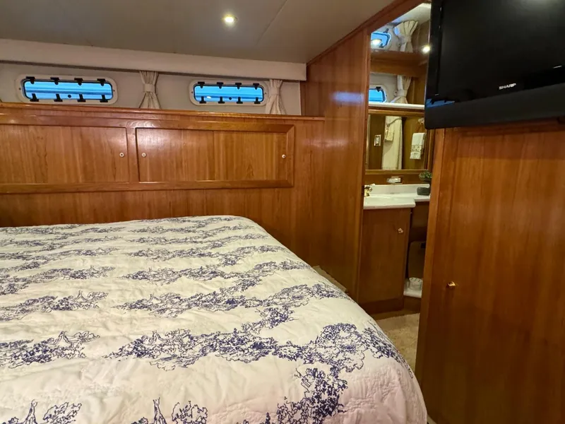 Slide: The Image of Luxurious bedroom interior of 2002 Navigator 5700 Rival yacht with wood paneling and cozy bedding. - 18