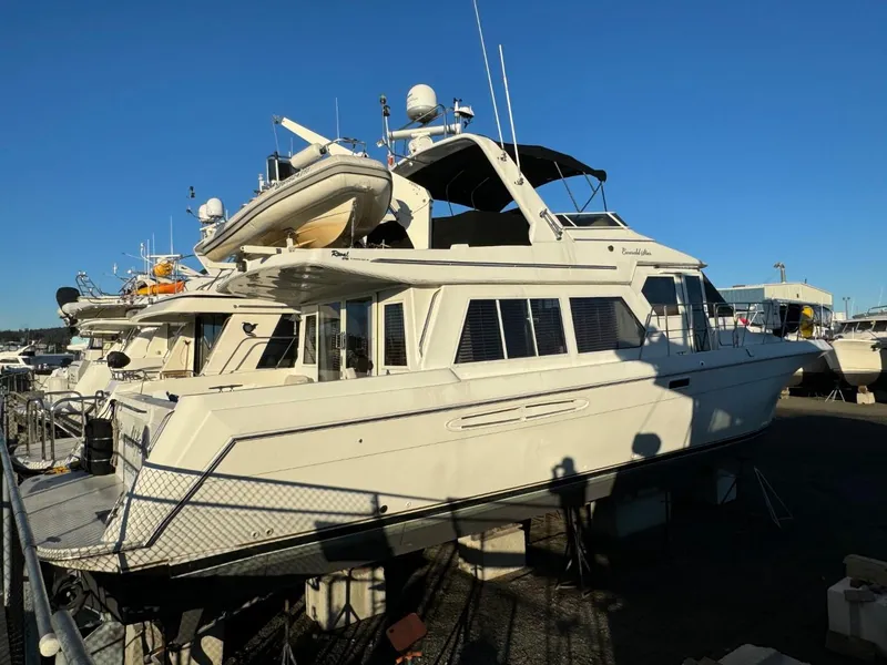 Slide: The Image of 2002 Navigator 5700 Rival yacht docked in marina under clear blue sky. - 2