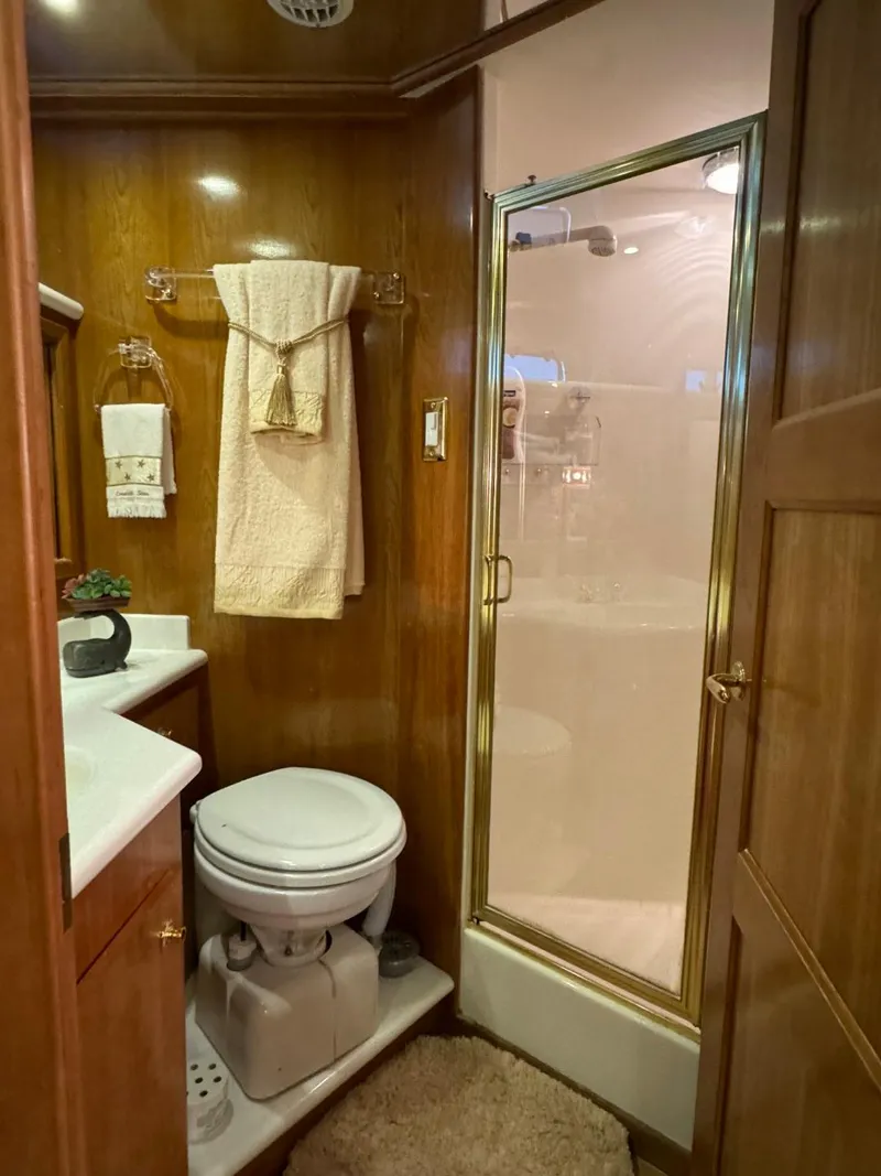 Slide: The Image of 2002 Navigator 5700 Rival bathroom with shower, toilet, and wooden cabinetry. - 22
