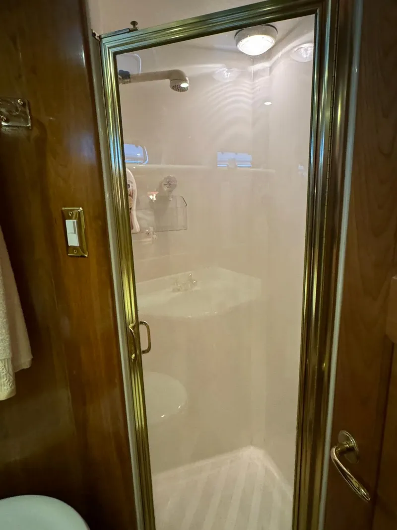 Slide: The Image of Shower area in 2002 Navigator 5700 Rival RV with glass door and wooden accents. - 23