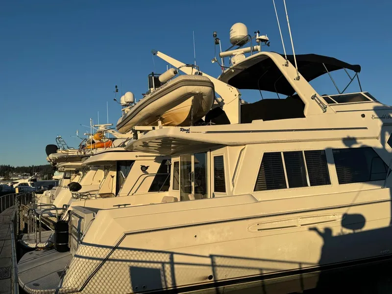 Slide: The Image of Luxury yachts docked, featuring a 2002 Navigator 5700 Rival under clear blue skies. - 3