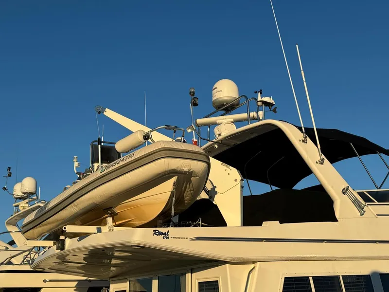 Slide: The Image of Luxury yacht Navigator 5700 Rival 2002 with mounted dinghy under clear blue sky. - 4