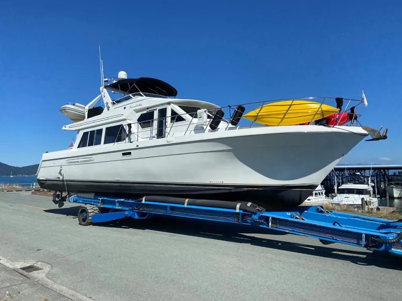 Slide: The Image of 2002 Navigator 5700 Rival yacht on trailer with kayaks, under clear blue sky. - 81
