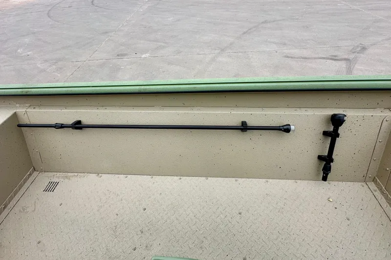 Slide: The Image of 2026 SeaArk Shadow 18 boat interior with rod holders and textured flooring. - 16