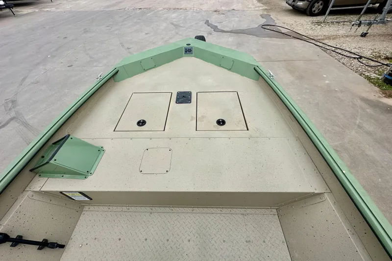 Slide: The Image of 2026 SeaArk Shadow 18 boat deck, featuring storage compartments and a green trim. - 17