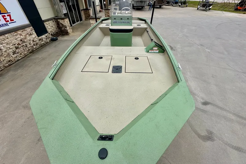 Slide: The Image of 2026 SeaArk Shadow 18 boat, green exterior, spacious deck, parked outdoors. - 9