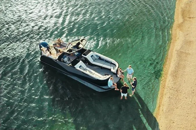 Slide: The Image of Aerial view of Flamingo ROVE 245 boat, 2026 model, near sandy shore with people relaxing. - 9
