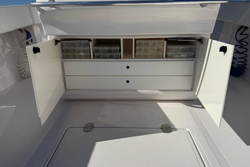 Slide: The Image of 2009 Venture 39 Open boat storage compartment with open doors and organized tackle boxes. - 13