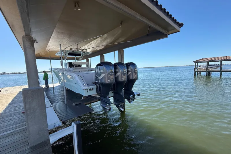 Slide: The Image of 2009 Venture 39 Open boat with triple Yamaha engines on a dock lift. - 6