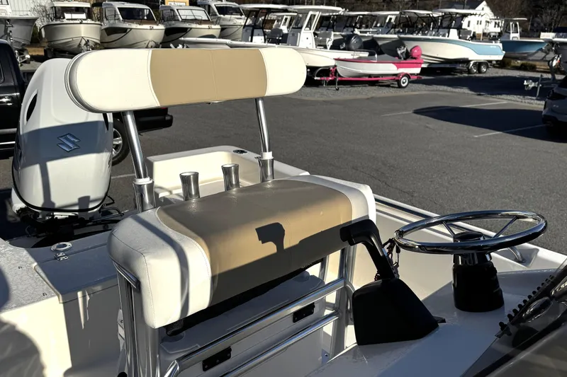 Slide: The Image of 2026 Bulls Bay 2000 boat interior with steering wheel and seating, parked among other boats. - 7