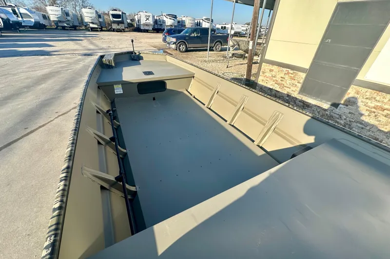 Slide: The Image of 2026 SeaArk 1652 Special boat interior, spacious layout, parked outdoors near RVs. - 10