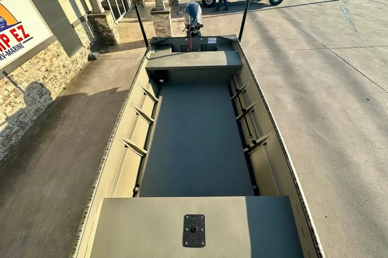 Slide: The Image of 2026 SeaArk 1652 Special boat, empty interior view, parked on concrete. - 15