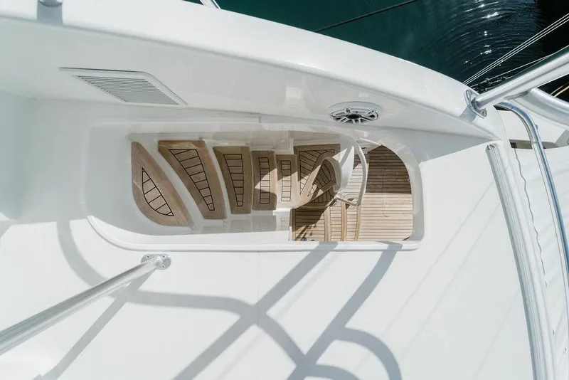 Slide: The Image of Overhead view of 2021 Viking 58 Convertible yacht's elegant wooden deck and seating area. - 104