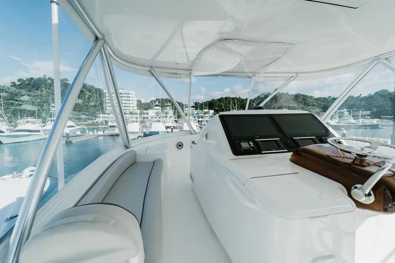 Slide: The Image of Interior view of 2021 Viking 58 Convertible yacht's helm with marina backdrop. - 118
