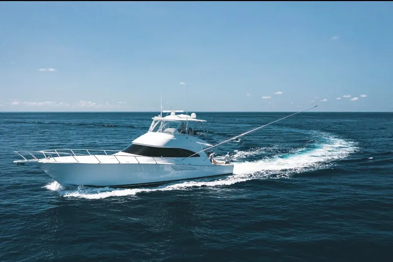 Slide: The Image of 2021 Viking 58 Convertible yacht cruising on open ocean under clear blue sky. - 2