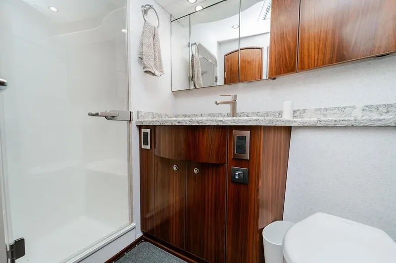 Slide: The Image of Luxurious bathroom in 2021 Viking 58 Convertible yacht with modern fixtures and wood cabinetry. - 25