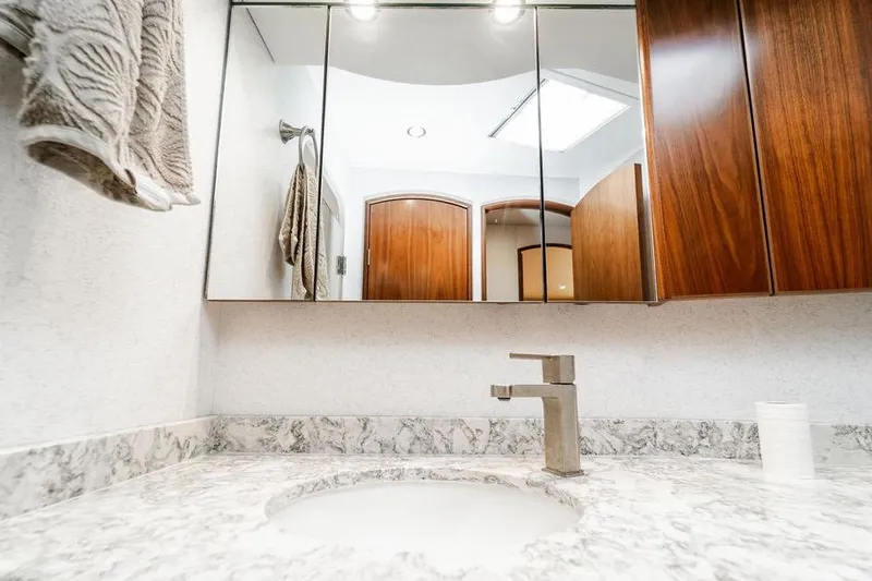 Slide: The Image of Modern bathroom vanity in 2021 Viking 58 Convertible yacht, featuring marble countertop and wooden cabinets. - 28