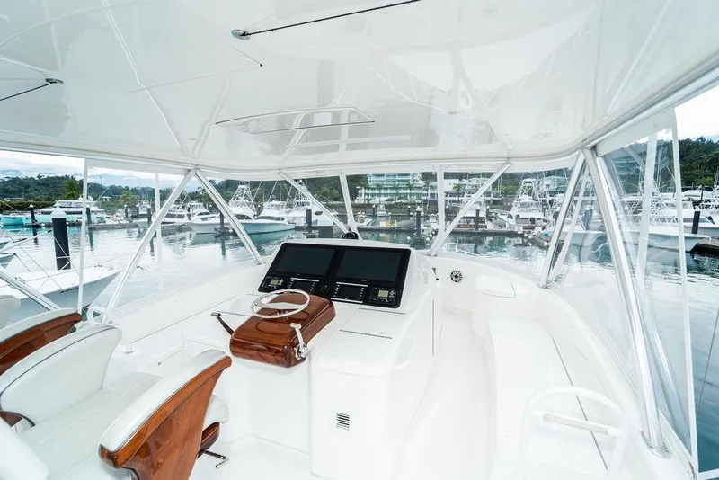 Slide: The Image of Luxurious 2021 Viking 58 Convertible yacht helm with marina view. - 30