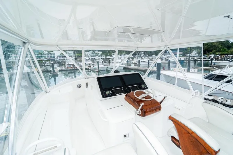 Slide: The Image of Helm of 2021 Viking 58 Convertible yacht with dual screens and wooden accents. - 31