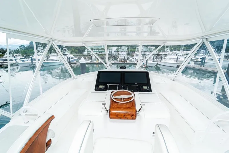 Slide: The Image of Cockpit view of 2021 Viking 58 Convertible yacht at marina. - 35