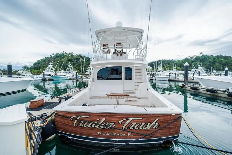 Slide: The Image of 2021 Viking 58 Convertible yacht docked in marina, featuring "Trailer Trash" nameplate. - 36