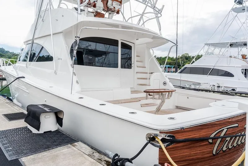 Slide: The Image of 2021 Viking 58 Convertible yacht docked, showcasing sleek design and spacious deck area. - 41