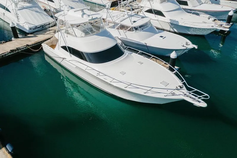 Slide: The Image of 2021 Viking 58 Convertible yacht docked in marina, surrounded by other boats. - 44
