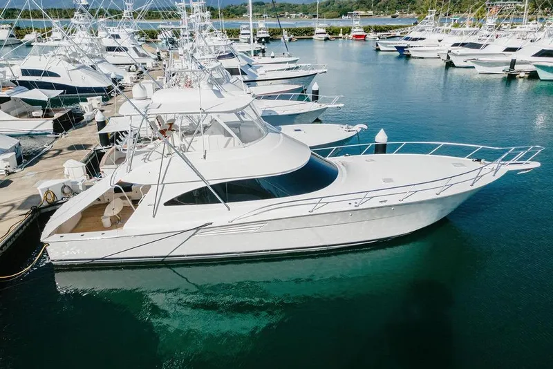 Slide: The Image of 2021 Viking 58 Convertible yacht docked in a marina, surrounded by other boats. - 49