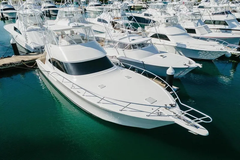 Slide: The Image of 2021 Viking 58 Convertible yacht docked in marina, surrounded by other boats. - 50