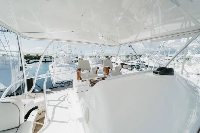 Slide: The Image of 2021 Viking 58 Convertible yacht interior with helm station and marina view. - 57